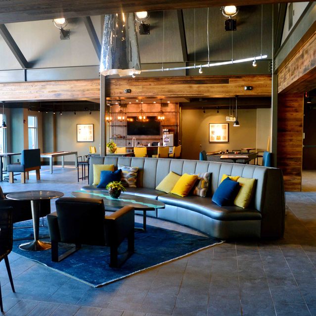 Encore at Forest Park - Community Lounge Area with Gray Sofa and Colorful Cushions